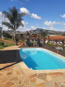a swimming pool with a view of a resort at Chácara Por do Sol in Pouso Alegre