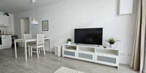 a living room with a television on a white entertainment center at LandRäume barrierefrei in Lunden