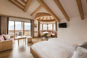 a bedroom with a bed and a living room at Hotel Nussbaumerhof *** in Rodengo +97 photos