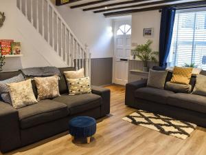 ein Wohnzimmer mit 2 Sofas und einer Treppe in der Unterkunft Low Quay Cottage in Conwy