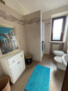 a bathroom with two toilets and a sink and a blue rug at Dimora La Casetta in Fradegola