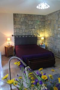 a bedroom with a bed and a stone wall at Maquis et plage in Sollacaro