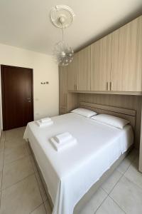 a bedroom with a large white bed and a chandelier at Casa Stella in Crotone