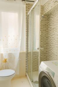 a bathroom with a toilet and a shower and a washing machine at Casa Stella in Crotone +7 photos