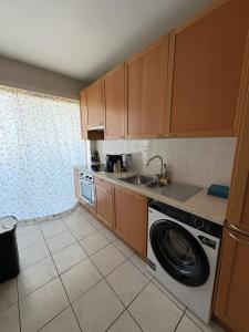a kitchen with a washing machine and a sink at Cosy apartment near Zaventem Airport in Brussels
