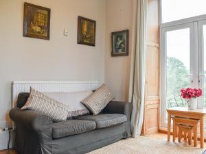 a leather couch in a living room with a window at Grosmont Villa in Grosmont +26 photos