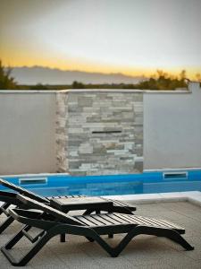 a lounge chair sitting next to a swimming pool at Villa Moderne MARIA-VIDA Piscine Medugorje 2km Mostar 22km in Međugorje