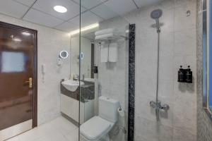 a bathroom with a toilet and a sink and a shower at Vendome Plaza Hotel in Dubai +31 photos
