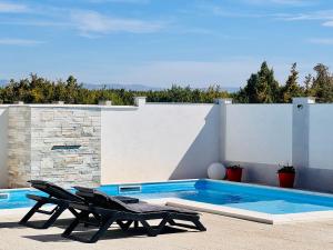 a swimming pool with two lounge chairs next to it at Villa Moderne MARIA-VIDA Piscine Medugorje 2km Mostar 22km in Međugorje +46 photos