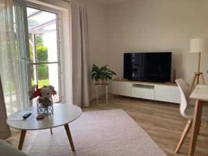 TV a/nebo společenská místnost v ubytování moderne 2-Zimmer-Wohnung mit überdachter Terrasse