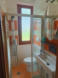 a bathroom with a toilet and a sink and a shower at Versilia - Casa vacanze con Giardino in Marina di Pietrasanta +25 photos