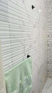 a bathroom with a shower with a green towel at Family Apartment in Marsa Alam 3 bed rooms in Marsa Alam City