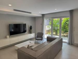 a living room with a couch and a flat screen tv at FRANE-APART - Čiovo in Trogir