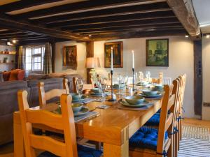 a dining room with a wooden table and chairs at Rose Cottage in Bethersden
