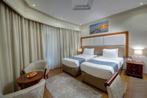 a hotel room with two beds and a table at Vendome Plaza Hotel in Dubai +44 photos