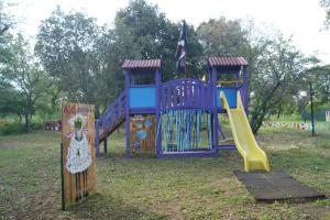 a playground with a slide in a park at Nuraghe Ruiu Camping & Bungalow in Norbello