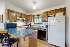 a kitchen with a white refrigerator and wooden cabinets at Bayside Retreat in Netarts +13 photos