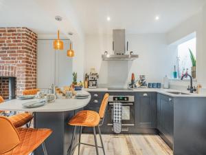 een keuken met een tafel en stoelen in een keuken bij Lavender Cottage in Coltishall