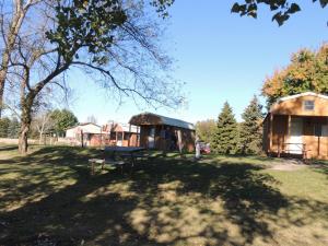 a park with a picnic table and two huts at O'Connell's RV Campground Lakefront Cabin 9 in Inlet