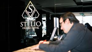 a man sitting at a table working on a laptop at The Ciao Stelio Deluxe Boutique Hotel - Adults Only in Larnaka +37 photos