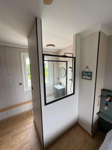a bathroom with a mirror and a sink in a room at Chambre 25m2 petit déjeuner en option in Roézé-sur-Sarthe