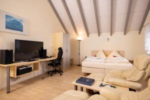 a living room with a couch and a tv at Engelhard Das Landhotel Garni in Kirchheim am Ries