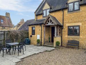 une maison avec une table et des chaises devant dans l'établissement Lavender Cottage, à Stretton on Fosse