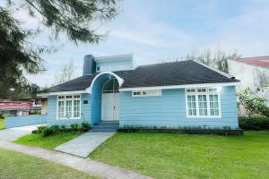 a blue house with a black roof at Villa Berastagi Indah A17 - TEBU MANIS in Berastagi