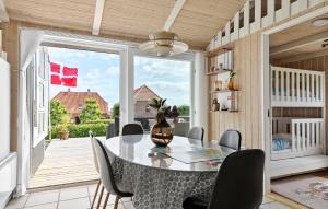 a dining room with a table and chairs and a large window at Amazing Home In Sjølund With Kitchen in Sjølund