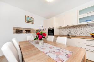 een keuken met een houten tafel en een vaas met bloemen bij Casa Sossi near Rovinj in Kanfanar