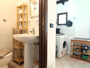 a bathroom with a sink and a washing machine at Petit Buragna in Alghero