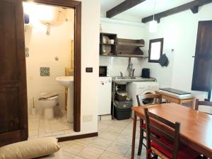 a kitchen and dining room with a table and a sink at Petit Buragna in Alghero