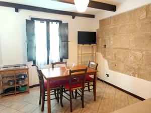 a dining room with a wooden table and chairs at Petit Buragna in Alghero +11 photos