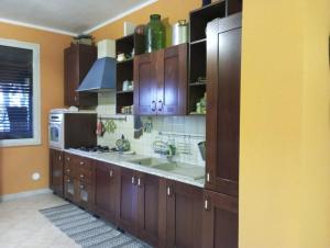 a large kitchen with wooden cabinets and a sink at Mami house in Sambuca di Sicilia