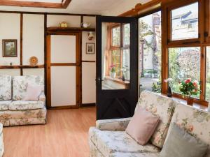 a living room with two couches and a door at The Old Workshop in Great Yarmouth