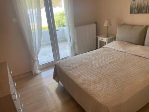a bedroom with a bed and a door to a balcony at Villa Fay in Preveza