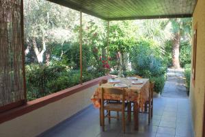 uma mesa e cadeiras num alpendre com vista para as árvores em Residence Giardino em Vieste