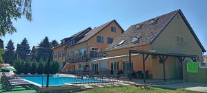 a building with a swimming pool next to a house at Tabán Vendégház in Balatonlelle +27 photos