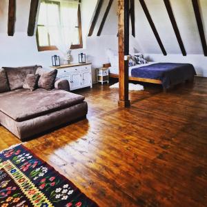 a living room with a couch and a bed at Cerdacul din livada - Șura Bunicilor in Vaideeni