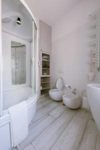 a white bathroom with two sinks and two toilets at Il Giardino della Giudecca Trani in Trani +15 photos