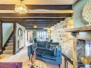 a living room with a blue couch and a stone wall at The Twisted Toad in Guisborough