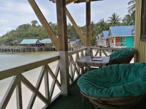 a porch with chairs and a table with a laptop on it at SokSan Seaview Cottage in Koh Rong Island