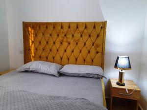 Schlafzimmer mit einem Bett mit einem Kopfteil aus Holz und einer Lampe in der Unterkunft Beskydy Holiday Rentals in Mbeya