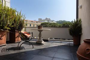 a table and chair on a balcony with potted plants at Charme & Comfort, Maison di Stile, Sestri Levante in Sestri Levante