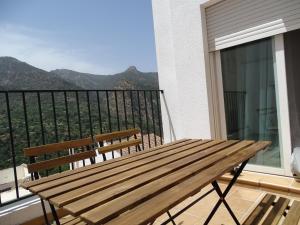 圭哈尔谢拉Escapada en la sierra, vistas y relax total的阳台顶部的木凳