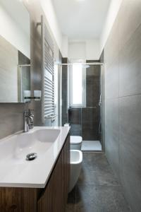 ペスキエーラ・ボッロメーオにあるVittoria House near Milan, Linate, Rho Fieraの白い洗面台とトイレのあるバスルーム