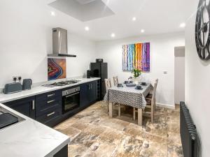 a kitchen with a table and a dining room at The Alnwick Townhouse in Alnwick