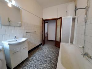 a bathroom with a sink and a tub and a toilet at GREEN DOLOMYTE Apartment in Schilpario
