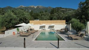 a swimming pool with lounge chairs and a resort at Elpida Luxury Apartments Suites in Nydri