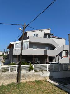 a white house with a fence in front of it at Luxury Apartment Ante in Kaštela